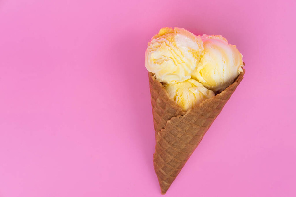 Fruit-scented ice cream balls in a waffle cone on a pink background - Φωτογραφία, εικόνα