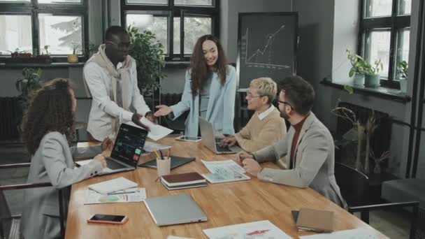 Medium slowmo portret van jonge multi-etnische team coworking in modern kantoor dan draaien om camera glimlachen - Video