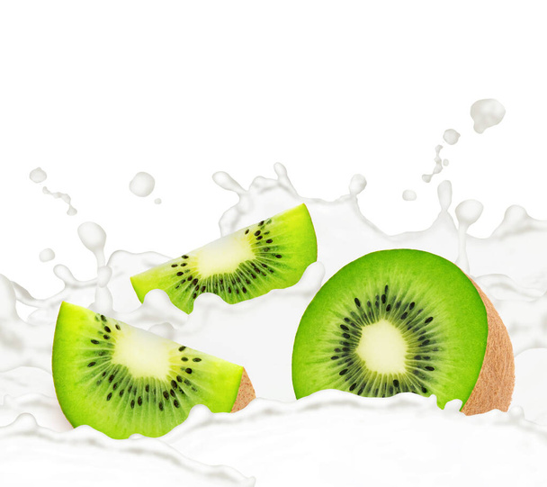 Gesneden kiwi in melk spatten geïsoleerd op witte achtergrond. - Foto, afbeelding