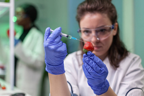 Biokémikus kutató közelsége, egészséges szamóca befecskendezése DNS folyadékkal - Fotó, kép