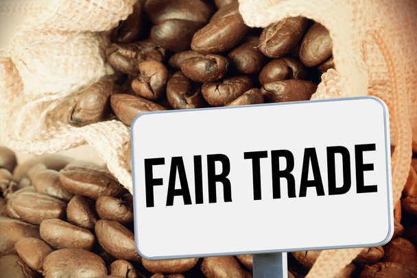 Een jute zak met koffie en een fair trade teken - Foto, afbeelding