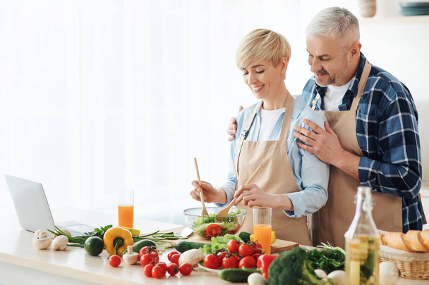 Senior couple bloggers recording video content, preparing healthy food in kitchen - Zdjęcie, obraz
