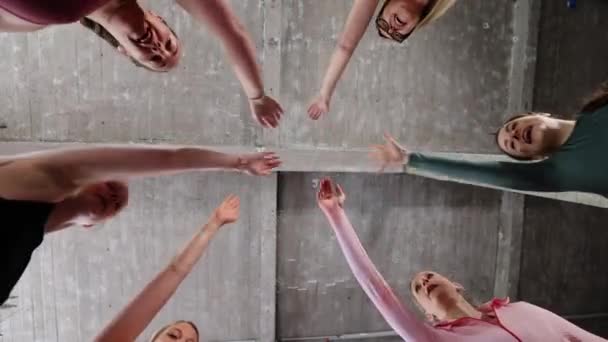 Grupa lub zespół szczęśliwych młodych kobiet sportowych w siłowni wszyscy rozweselają się z podniesionymi rękami i oklaskami - Materiał filmowy, wideo