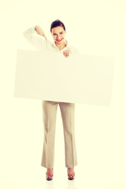 Woman pointing on blank poster - Valokuva, kuva
