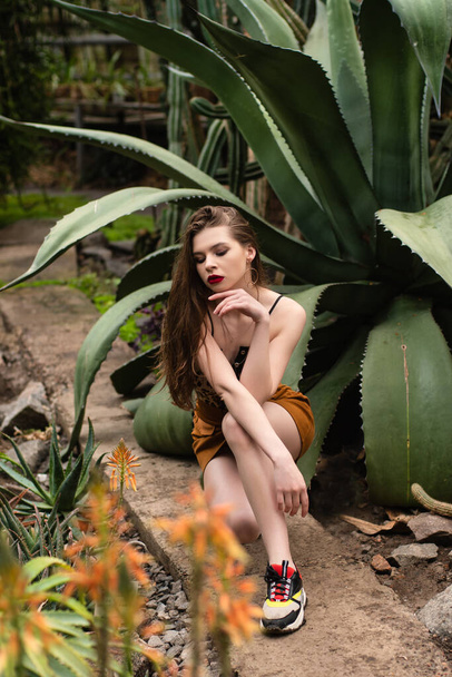 Csinos fiatal lány pózol az egzotikus kertben - Fotó, kép