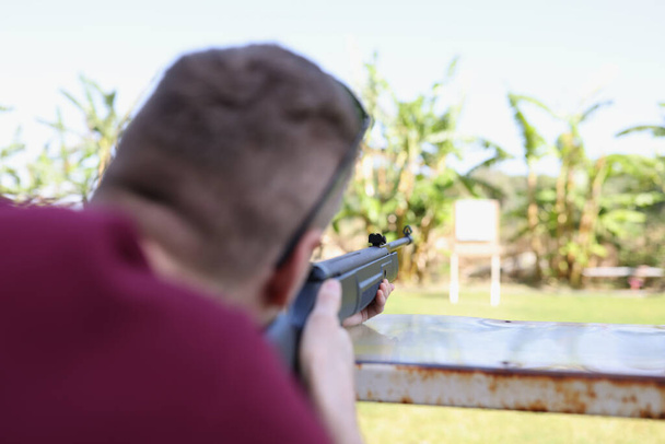 Hombre dispara un arma en el blanco en el campo de tiro de la calle - Foto, imagen