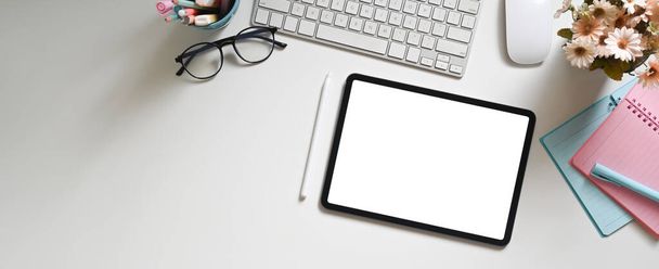 Top view fehér munkaterület veszi körül egy fehér üres képernyős számítógép tabletta és a különböző berendezések. - Fotó, kép