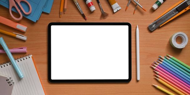 La imagen de vista superior del espacio de trabajo del artista está rodeada por una tableta y cosas de computadora en blanco blanco. - Foto, Imagen
