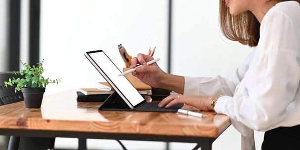 Kuva stylisti nainen suunnittelee uuden projektin käyttämällä kynä ja tietokone tabletti moderni puinen pöytä yli mukava olohuone tausta. - Valokuva, kuva