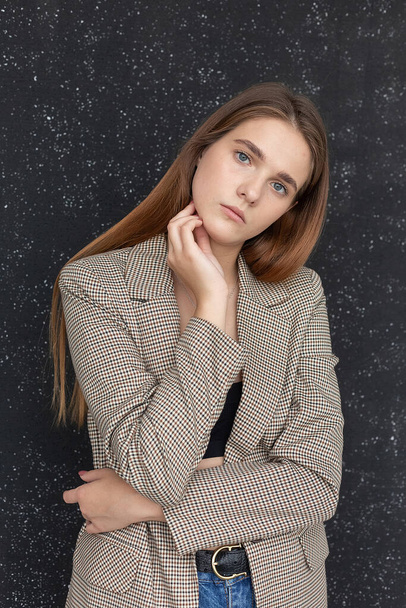 young attractive caucasian woman with long hair in black top and suit jacket - Fotó, kép