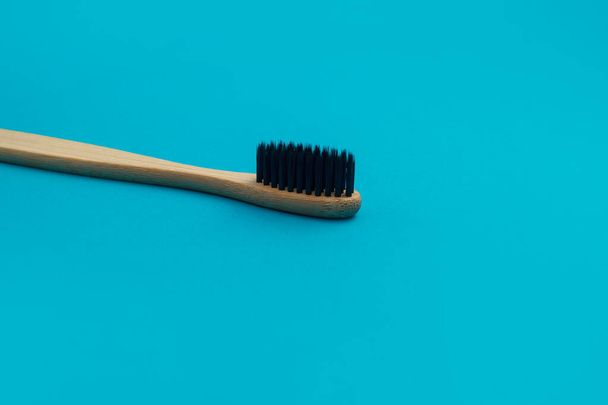 Wooden toothbrush on blue background - 写真・画像