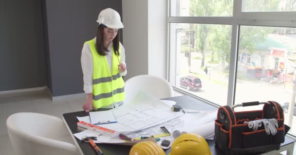 Γυναίκα μηχανικός με σχέδια στο γραφείο - Πλάνα, βίντεο