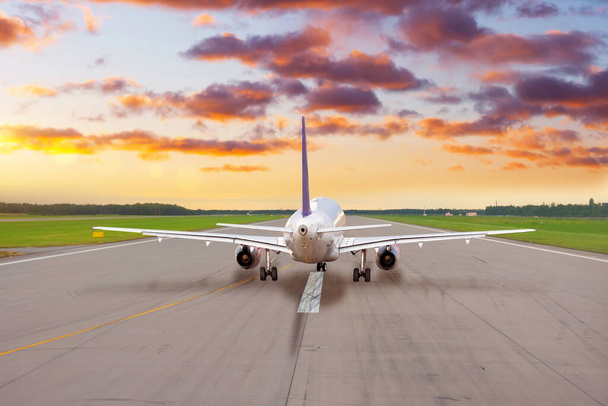 Avião de passageiros na pista pronto para decolar à noite ao pôr-do-sol - Foto, Imagem