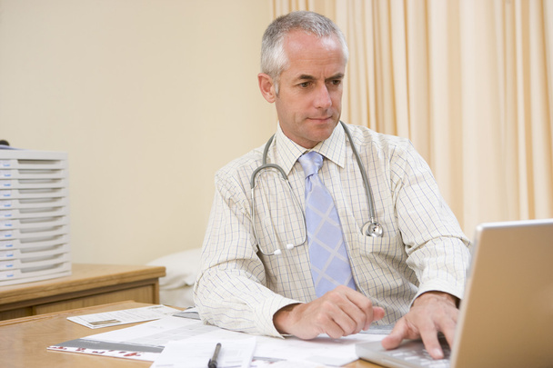 Doctor using laptop in doctor's office - Φωτογραφία, εικόνα