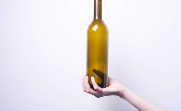 το χέρι μιας γυναίκας που κρατά ένα γυάλινο μπουκάλι - Φωτογραφία, εικόνα