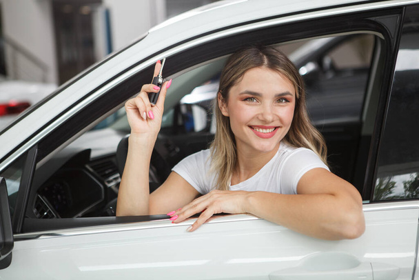 Beautiful cheerful woman holding car keys, sitting in her new automobile - Zdjęcie, obraz