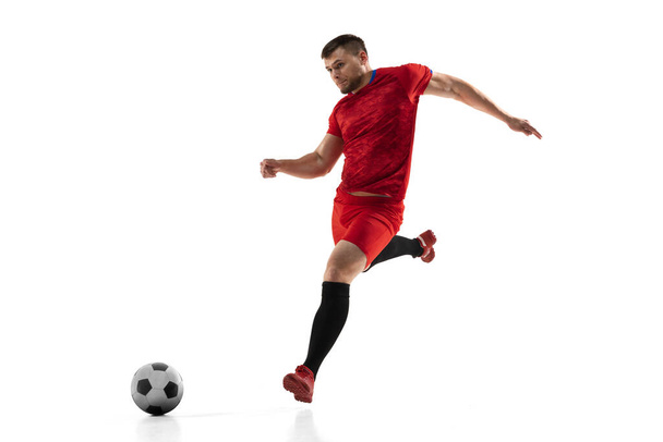 Mocný, letí nad hřištěm. Mladý fotbal, fotbalista v akci, pohyb izolovaný na bílém pozadí . - Fotografie, Obrázek