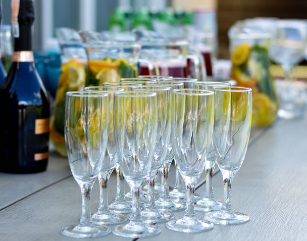 Υπάρχουν πολλά διαφορετικά ποτά και γυάλινα ποτήρια στο τραπέζι.Catering. - Φωτογραφία, εικόνα