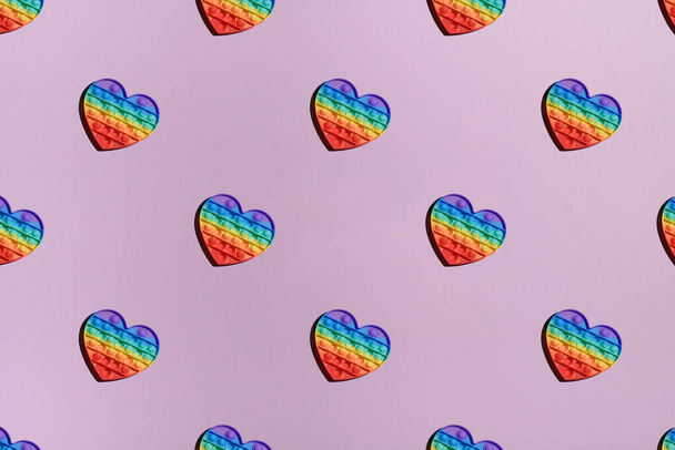 patroon regenboog pop it fidget speelgoed op roze achtergrond, bovenaanzicht, voor ontwerp - Foto, afbeelding
