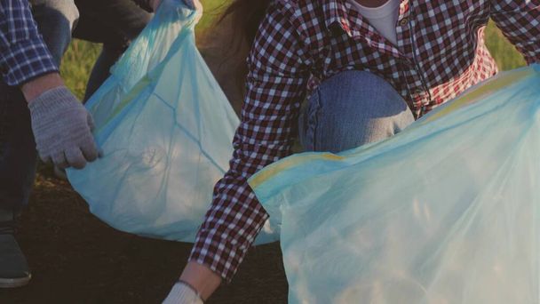 Grupa wolontariuszy zbiera śmieci w workach na śmieci, czyszcząc ekologię zielonej natury ze śmieci, koncepcja szczęśliwej rodziny, czysta planeta dla człowieka, środowisko jest w niebezpieczeństwie - Zdjęcie, obraz
