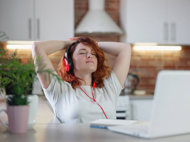Funky hipster woman listening favorite song or music podcast in headphones using app at home, happy funny young lady wearing headset enjoying new audio tracks playing in digital application - Photo, Image