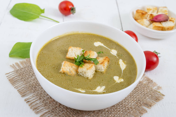 Diet puree soup with spinach and croutons in a white bowl. Proper nutrition. - Photo, Image