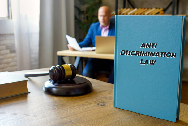  ANTI DISCRIMINATION RECHT boek in handen van een jurist. De antidiscriminatiewet bevat een aantal broodnodige definities van discriminatie. - Foto, afbeelding