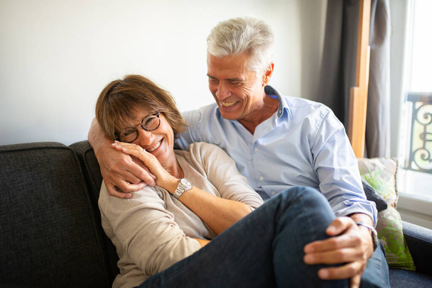 Muotokuva onnellinen vanhempi pari istuu sohvalla  - Valokuva, kuva