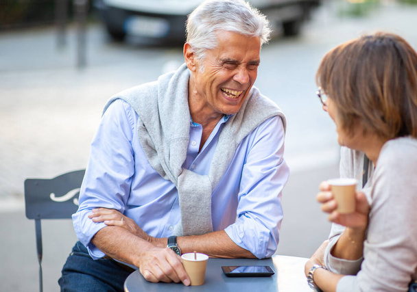 Πορτρέτο ευτυχισμένο ώριμο ζευγάρι κάθεται έξω με φλιτζάνια καφέ - Φωτογραφία, εικόνα