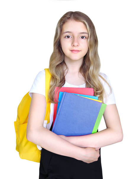 Child girl with books and backpack isolated on white. Caucasian pupil portrait.Schoolgirl. Teenager education concept. - 写真・画像