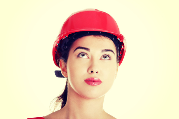 Confident female worker in helmet looking up. - Foto, Imagen