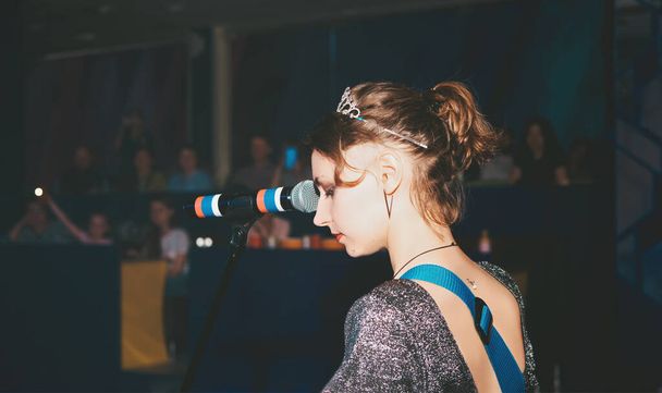 жіноча кавказька співачка виконує пісню на сцені. співачка, емоційний пристрасний вокаліст. публічний концерт рок-музики. вид ззаду
 - Фото, зображення