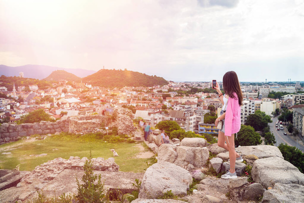 Jonge vrouw maakt foto 's van oude Romeinse ruïnes in de Europese culturele hoofdstad Plovdiv - Foto, afbeelding