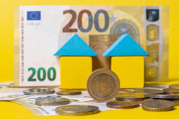 Евро различных номиналов, банкнота 200 евро и два символических домика для игрушек - Фото, изображение