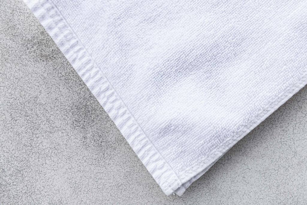 Καθαρές λευκές πετσέτες διπλωμένες σε λευκό ξύλινο τραπέζι. - Φωτογραφία, εικόνα