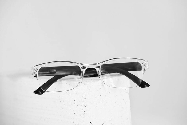 Óculos elegantes na pedra da moda. Loja óptica, seleção de óculos, teste ocular, exame de visão no óptico, conceito de acessórios. foco seletivo - Foto, Imagem