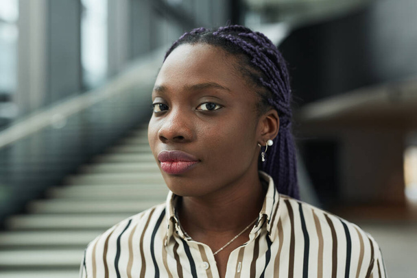 Retrato de cerca de la joven mujer de negocios afroamericana mirando a la cámara mientras posaba en el salón de oficinas, espacio para copiar - Foto, imagen