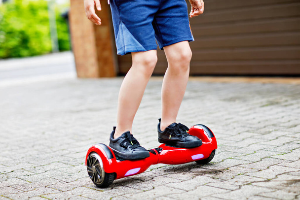 Close-up of kid boy on hover board. Child driving modern balance hoverboard. Excercise and sports for children, outdoor activity for young kids. - Valokuva, kuva