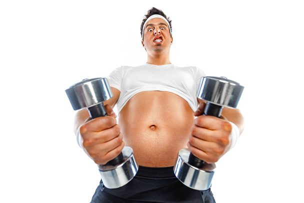 Fat man doing workout traning with dumbbells. Happy guy isolated over white background. - Fotó, kép