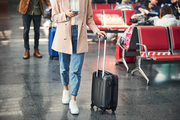 Elegante giovane donna utilizzando il cellulare in aeroporto - Foto, immagini