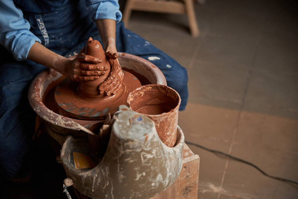 Beautiful elegant ceramicist in apron modeling tableware in pottery workshop - Фото, изображение