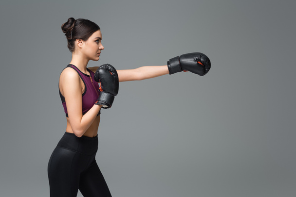 vue latérale de la femme en boxe sportive noire isolée sur gris - Photo, image