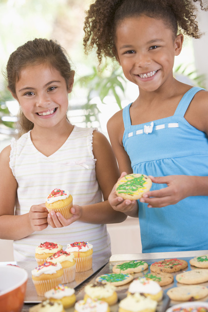 Two children in kitchen decorating cookies smiling - Φωτογραφία, εικόνα