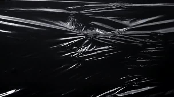 Siyah arkaplanda plastik ambalaj deseni - Video, Çekim