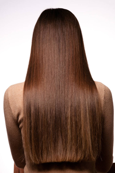 Fényképezés női frizura portré hátulról tiszta egyenes hosszú haj fehér háttér közelkép. - Fotó, kép