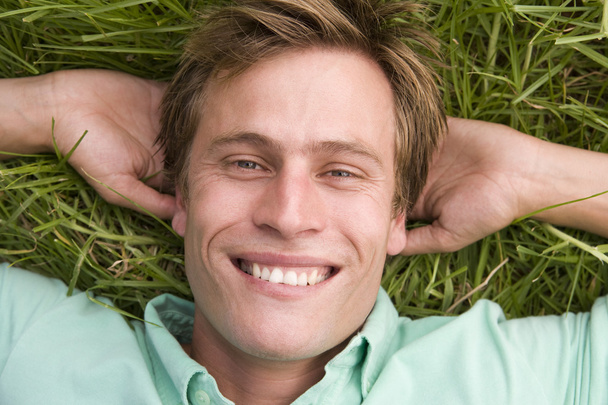 Man lying on grass smiling - Zdjęcie, obraz