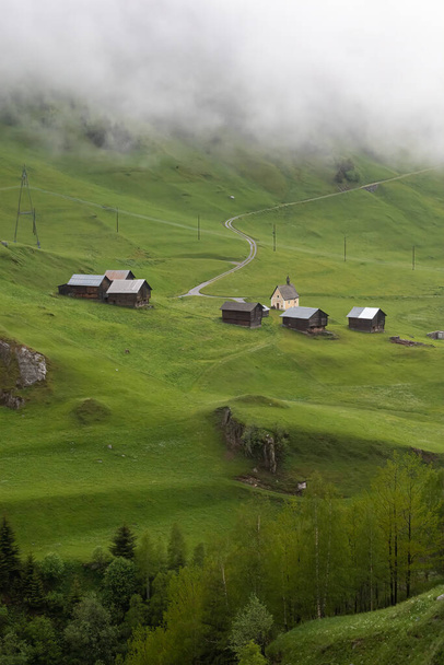 Misty and rainy day at Curaglia in swiss mountain valley in direction of Lukmanier mountain pass. - Photo, Image