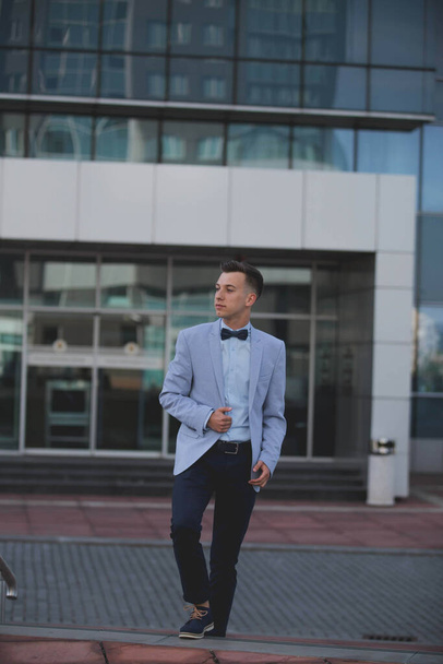 The stylish young man in a suit in front of a modern building - Fotografie, Obrázek