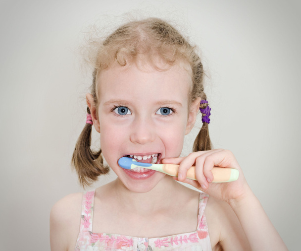 Маленькая девочка чистила зубы зубной щеткой
. - Фото, изображение