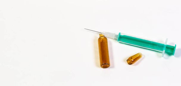 A closeup shot of a syringe and a broken ampule on an isolated background - Photo, Image